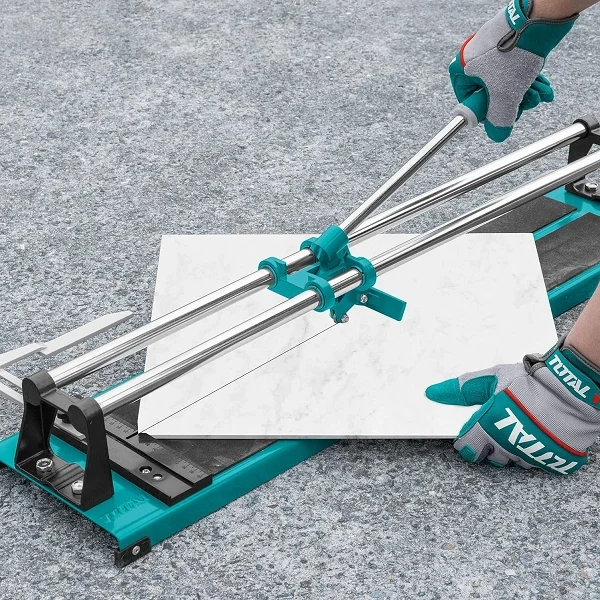 Main effectuant une coupe de carreau sur le coupe-carreaux manuel 600 mm.
