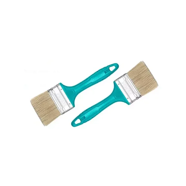 Main utilisant un pinceau plat 50mm Total pour peindre une surface en bois.