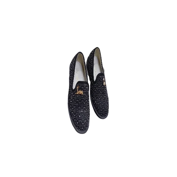 Paire de chaussures habillées pour enfant, noires avec des paillettes grises, une bride à boucle, et un médaillon décoratif doré.