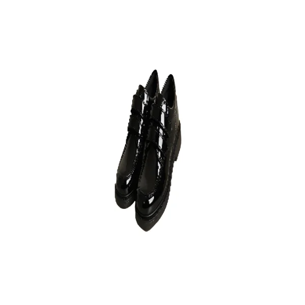 Paire de chaussures noires pour garçon en cuir verni, avec deux lanières à scratch et une semelle plateforme épaisse, posées sur une table.