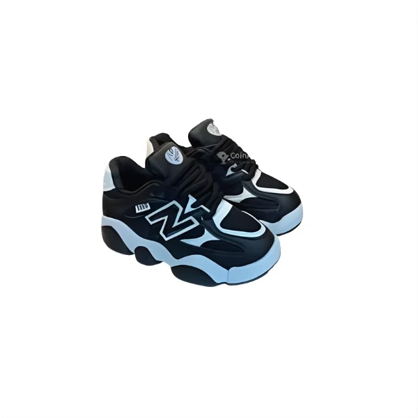 Paire de baskets noires et blanches de style New Balance pour enfant, avec une semelle épaisse et un logo en forme de 'N' sur le côté.